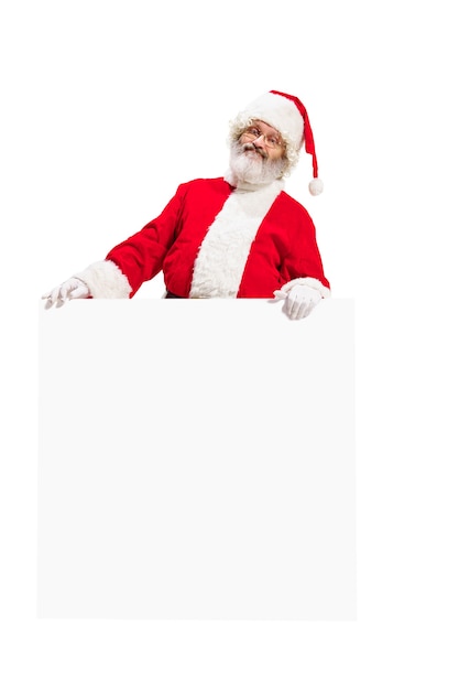 Heureux père Noël surpris pointant sur une bannière publicitaire vierge avec espace de copie
