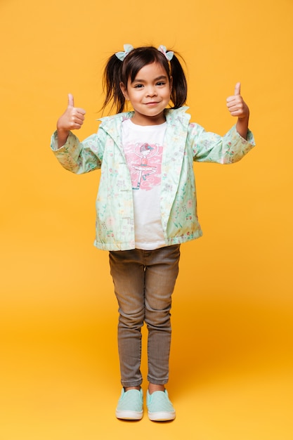 Heureux petit enfant fille debout isolé