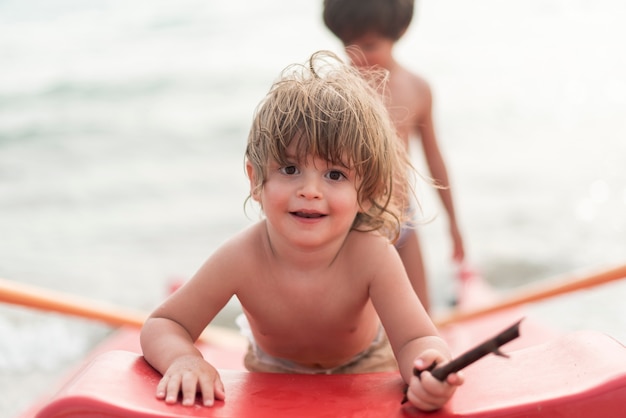 Photo gratuite heureux petit enfant sur une planche de paddle