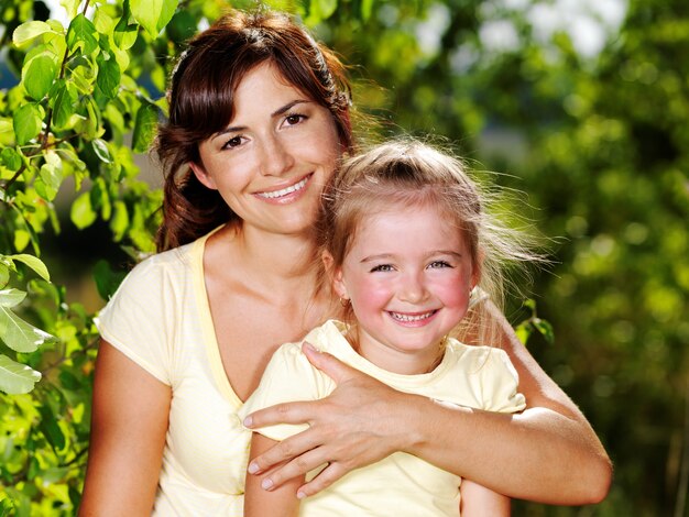 Heureux portrait de la mère et de la petite fille à l'extérieur