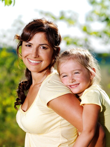 Heureux portrait de la mère et de la petite fille à l'extérieur