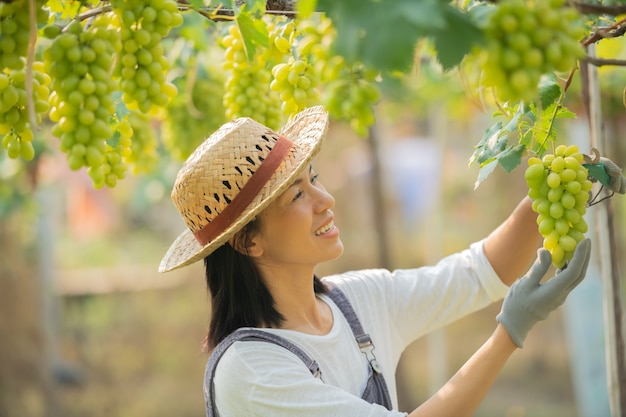 Heureux souriant joyeux vignoble femelle portant une salopette et un chapeau de paille robe de ferme