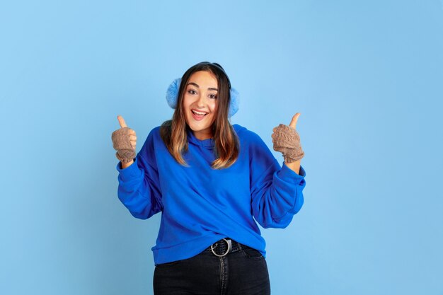 Heureux souriant. Portrait de femme caucasienne sur l'espace bleu. Beau modèle féminin dans des vêtements chauds