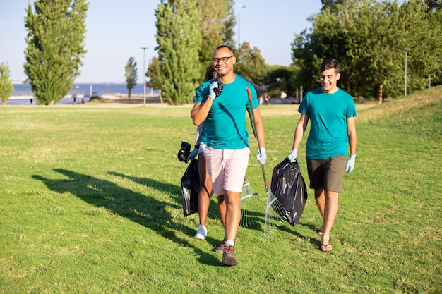 Heureux volontaires amicaux portant des déchets