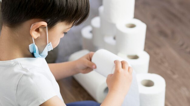 High angle boy jouer avec du papier toilette