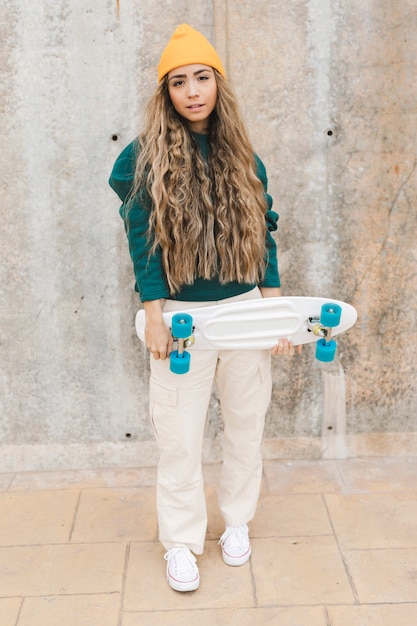 Photo gratuite high angle woman holding skateboard