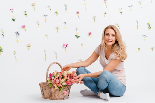 Photo gratuite high angle woman with basket of flowers