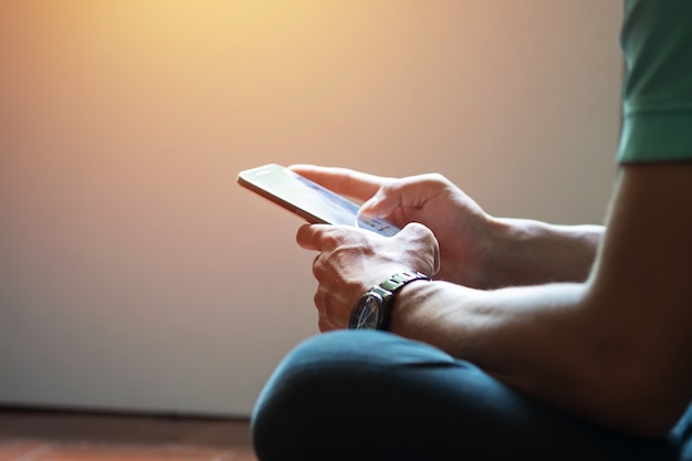 Hipster à l&#39;aide d&#39;un écran tactile, le téléphone intelligent se rapproche, les couleurs anciennes.
