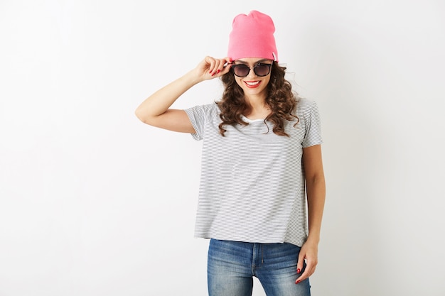 Hipster jolie femme au chapeau rose, lunettes de soleil, danse heureuse, visage souriant, cheveux longs, humeur positive, émotionnelle, tenue de style hipster, tendance de la mode estivale, jeans et t-shirt rayé, isolé