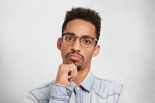 Hmm pas mal. Close up portrait en studio de gestionnaire masculin sérieux concentré ou patron évalue le travail d'autres personnes