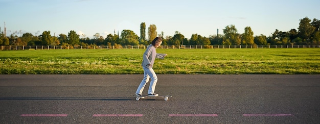 Photo gratuite hobbys et mode de vie jeune femme faisant du skateboard skater fille profitant d'une croisière sur longboard sur