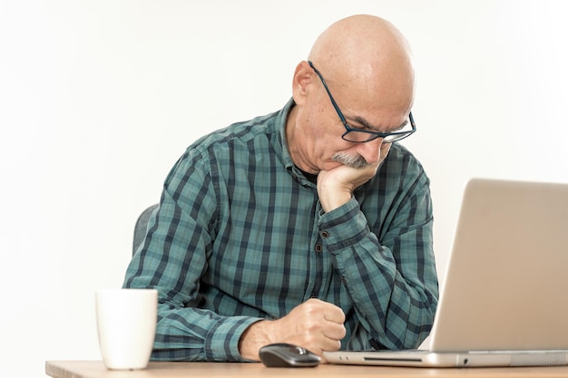 Un homme de 60 ans se fâche contre l'ordinateur et serre le poing