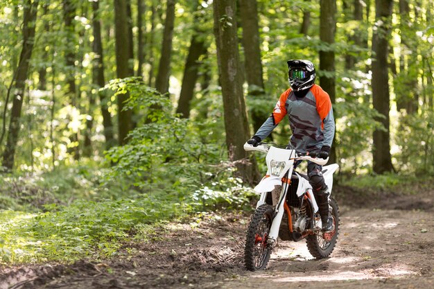 Homme actif à moto dans la forêt