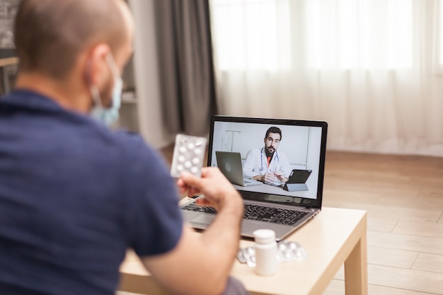 Homme adulte parlant avec un médecin de son traitement pendant la pandémie mondiale.