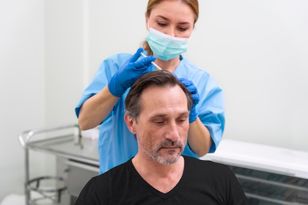 Homme adulte recevant un traitement contre la perte de cheveux