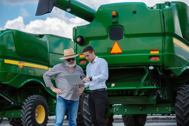 Photo gratuite homme d'affaires et agriculteur avec des tracteurs