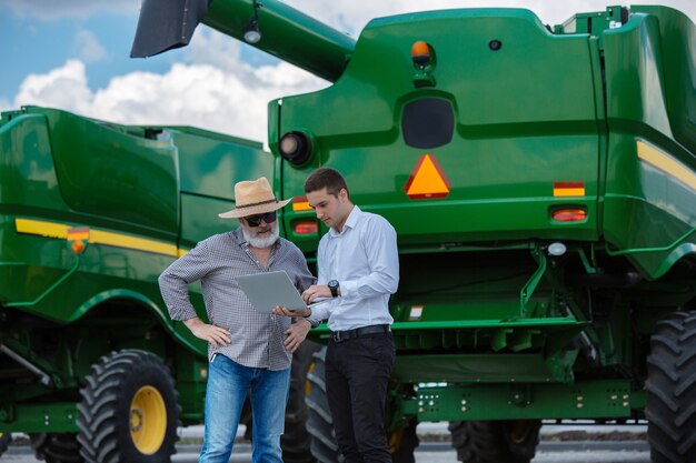 Homme d'affaires et agriculteur avec des tracteurs