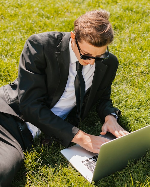 Homme d&#39;affaires à l&#39;aide d&#39;un ordinateur portable sur l&#39;herbe verte