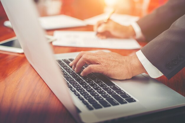 Homme d&#39;affaires analysant les graphiques d&#39;investissement avec un ordinateur portable dans le bureau.