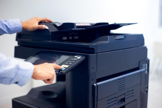 Homme d'affaires appuyez sur le bouton à la main sur le panneau de l'imprimante, le laser du scanner de l'imprimante dans le concept de démarrage des fournitures de copie de bureau.