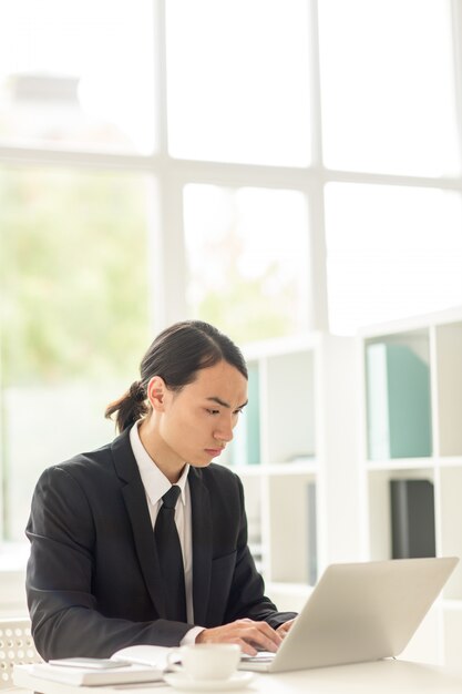 Homme d'affaires asiatique enveloppé dans le travail