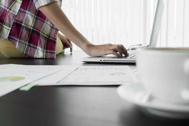 Homme d&#39;affaires assis à table et dactylographie sur ordinateur portable