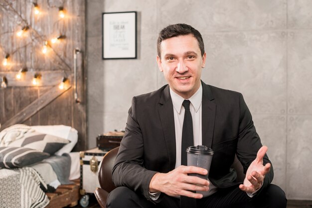 Homme d'affaires assis avec une tasse de café dans la chambre