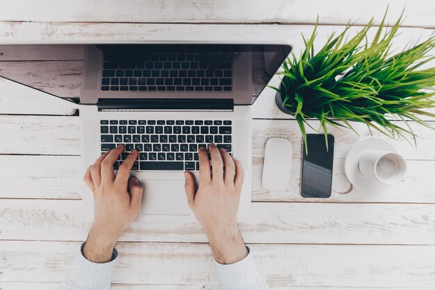 Homme d'affaires au travail vue de dessus en gros plan de l'homme travaillant sur un ordinateur portable