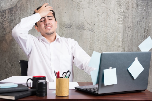 Photo gratuite homme d'affaires ayant des maux de tête au bureau.