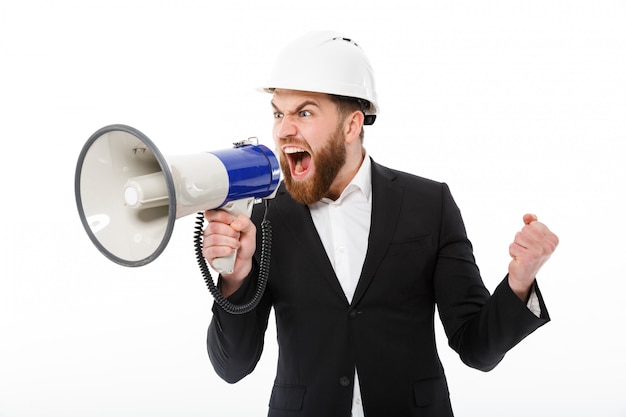 Photo gratuite homme d'affaires barbu en colère dans un casque de protection hurlant dans un mégaphone