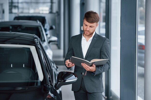 Homme d'affaires barbu élégant et moderne dans le salon automobile