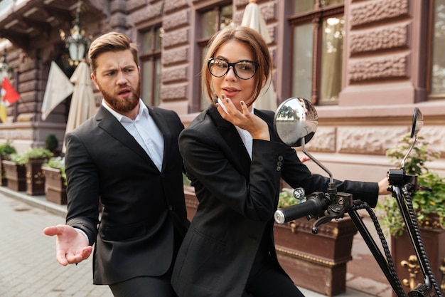 Photo gratuite homme d'affaires barbu mécontent assis sur une moto moderne à l'extérieur