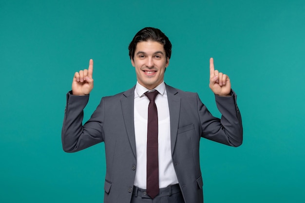 Homme d'affaires beau jeune homme brune en costume de bureau gris et cravate pointant vers le haut