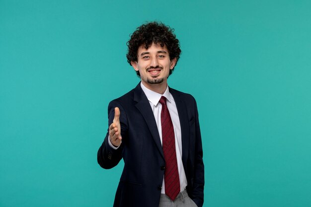 Homme d'affaires bouclé mignon beau mec en costume noir donnant la poignée de main