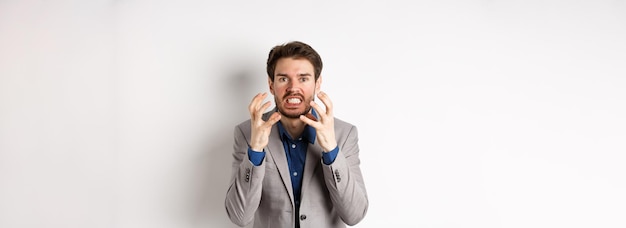 Un homme d'affaires en colère et agacé veut tuer quelqu'un en serrant les mains et les dents qui a l'air fou devant la caméra