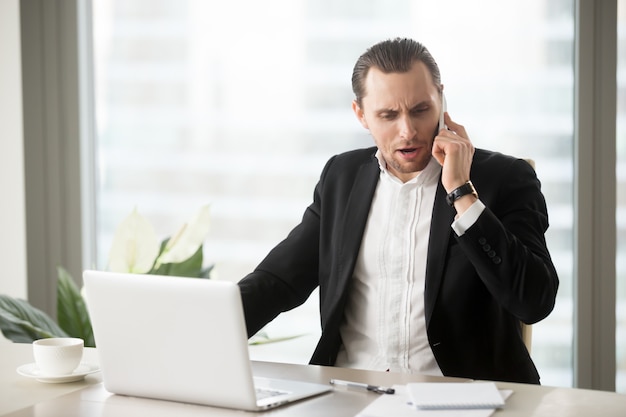 Homme d&#39;affaires en colère parlant au téléphone portable