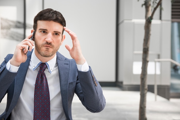 Photo gratuite homme d'affaires en colère parlant sur smartphone