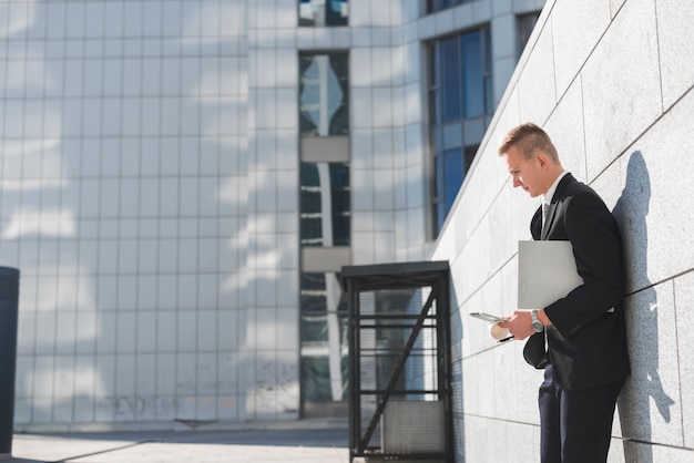 Homme d&#39;affaires à côté du mur