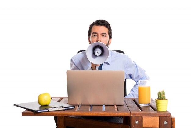 Homme d&#39;affaires dans son bureau criant par mégaphone