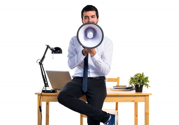 Homme d&#39;affaires dans son bureau criant par mégaphone