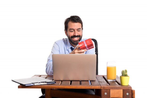 Homme d&#39;affaires dans son bureau en donnant un cadeau