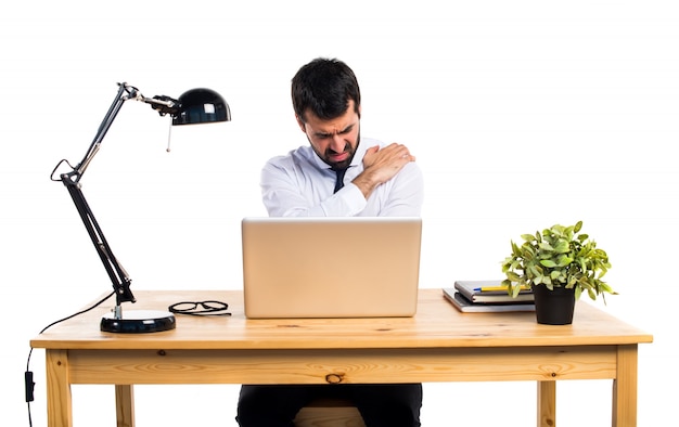Photo gratuite homme d'affaires dans son bureau avec douleur à l'épaule