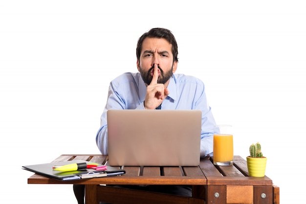 Homme d&#39;affaires dans son bureau faisant un geste de silence