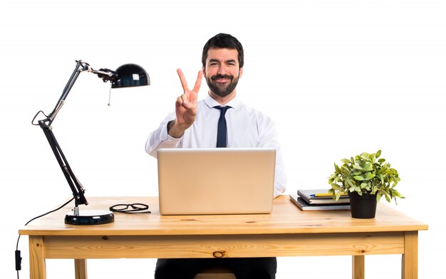 Homme d&#39;affaires dans son bureau faisant un geste de victoire