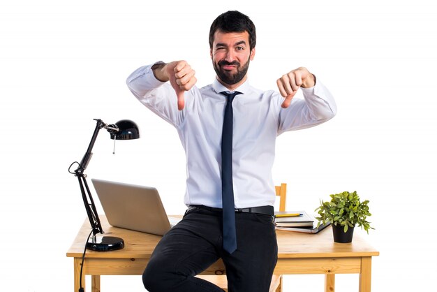 Homme d&#39;affaires dans son bureau faisant un mauvais signal