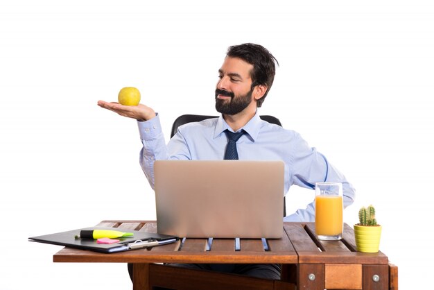 Homme d&#39;affaires dans son bureau tenant une pomme