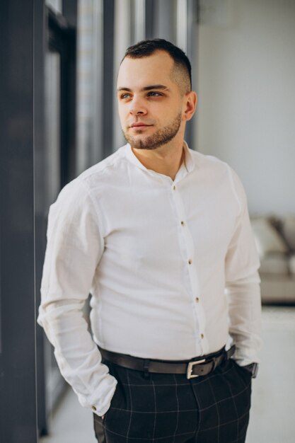 Photo gratuite homme d'affaires debout au bureau près de la fenêtre