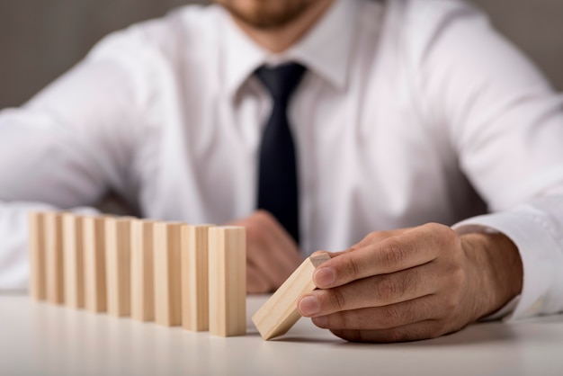 Homme d'affaires défocalisé en costume-cravate avec des dominos