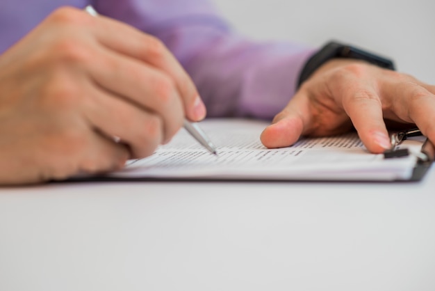 Homme d&#39;affaires écrit dans un cahier alors qu&#39;il était assis à un bureau