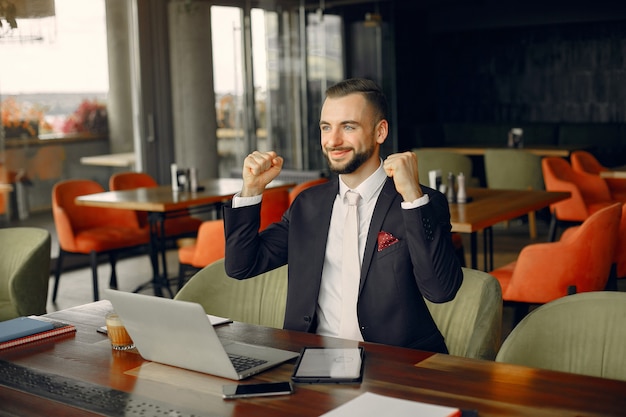 Photo gratuite homme d'affaires élégant travaillant dans un café